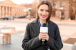 Beautiful journalist with microphone outdoors