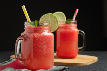 Wall Mural - Watermelon smoothie with lime and mint in mug jars on a cutting board. Healthy eating concept