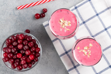 Wall Mural - Two glasses with freshly homemade smoothie of yogurt, oatmeal and cranberries on a gray table. Healthy eating concept