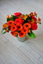Colorful Orange And Red Floral Arrangement With Freesia Flowers, Gerbera Daisies And Roses