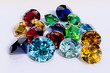 Multiple colorful faceted gems on white background