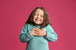 canvas print picture - Cute grateful little girl with hands on chest against pink background