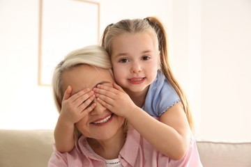 Wall Mural - Mature woman with her little granddaughter at home