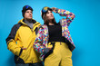 © New Africa - Couple wearing stylish winter sport clothes on light blue background, low angle view