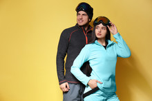 Couple Wearing Stylish Winter Sport Clothes On Yellow Background