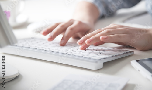 Fotomural Hands typing on computer keyboard in office desk.
