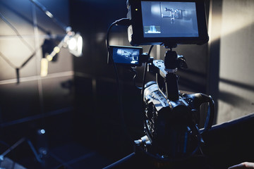 Video production backstage. Behind the scenes of creating video content, a professional team of cameramen with a director filming commercial ads. Video content creation, video creation industry. Low