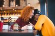 © Sanja - Two female friends laughing out loud in a cafe, having a good time.