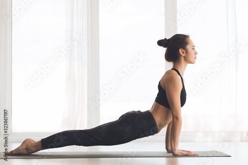 Fotomural Woman doing cobra pose at modern studio