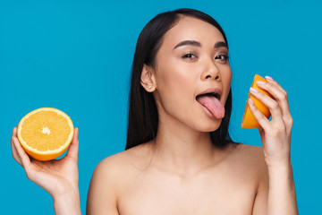 Canvas Print - Woman posing isolated licking orange.