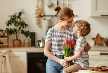 happy mother's day! child son gives flowers for mother on holiday .