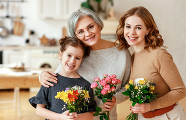 Wall Mural - mother's day! three generations of  family mother, grandmother and daughter congratulate on the holiday, give flowers .