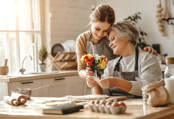 Canvas Print - happy mother's day! family old grandmother  mother-in-law and daughter-in-law daughter congratulate on   holiday, give flowers .