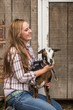 © MACO - Young western girl on a ranch petting a goat. Bridger, Montana, USA