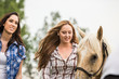 © MACO - Two girls pet and lead a mare in a pasture. Bridger, Montana, USA
