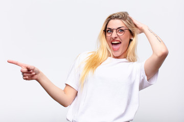 young pretty blonde woman laughing, looking happy, positive and surprised, realizing a great idea po