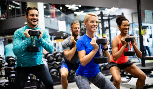 Fotografía Group of young happy fit people doing exercises in gym