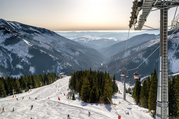 Wall Mural - View from cableway on slope and skiers in resort Chopok Juh, Slovakia