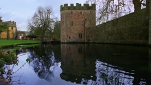 A Low Shot Across The Moat Toward The Wall And Main Gate Tower Of The Medieval Bishop's Palace Castle In Well, UK