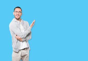 Puzzled young man doing a gesture of not understand