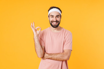 Canvas Print - Image of muscular athletic young man smiling and gesturing ok fingers