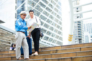 Travel and tourism concept. Happy Senior couple woman and man traveling together looking for destination with city map