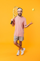 Sticker - Image of athletic young man holding rackets while playing tennis