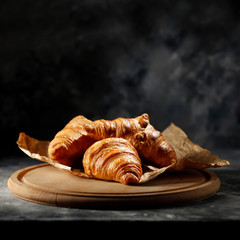 Sticker - Fresh croissant on dark mood background and copy space for your product. 