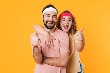 Canvas Print - Portrait of athletic young couple smiling and gesturing thumbs up