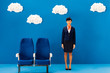 © LIGHTFIELD STUDIOS - smiling african american flight attendant standing near seat on blue background with clouds