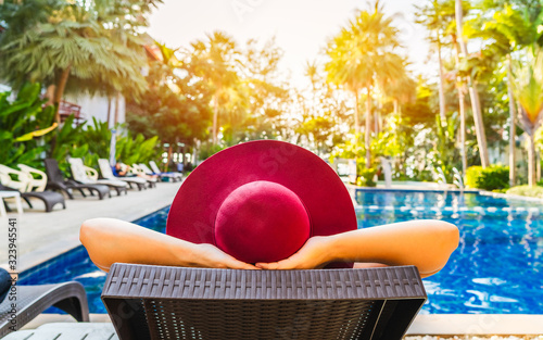 Cuadros en Lienzo Summer lifestyle traveler woman relaxing in front of modern luxury swimming pool