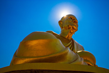 Buddha statue of Luang Pho Tuat On the beautiful sun and sky background