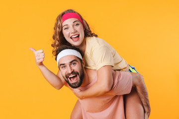 Wall Mural - Portrait of athletic happy couple smiling while doing piggyback ride