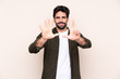 © luismolinero - Young handsome man with beard over isolated background counting eight with fingers