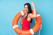 Lifeguard woman over isolated blue background with lifeguard equipment and doing strong gesture