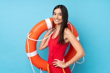 Lifeguard woman over isolated blue background with lifeguard equipment and with happy expression