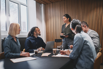 Wall Mural - Smiling businesswoman meeting with colleageus in an office board