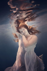 Wall Mural - Portrait of a girl in a dress under water