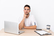 © luismolinero - Young business man with a mobile phone in a workplace thinking an idea
