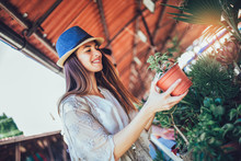 Young Woman Buying Flowers At A Garden Center