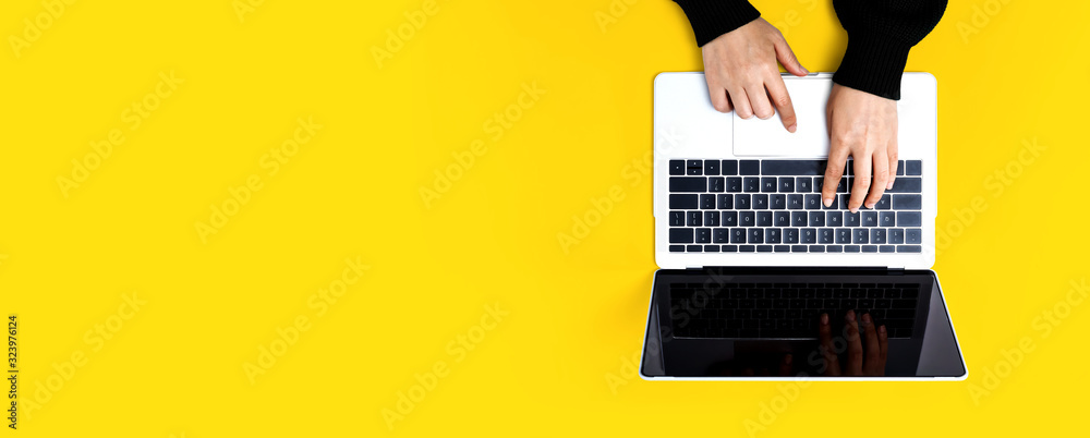 Person using a laptop computer on a solid color background - obrazy, fototapety, plakaty 