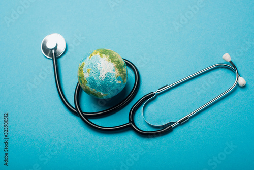 Cuadros en Lienzo Globe and stethoscope on blue background, world health day concept
