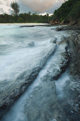 Wall Mural - Waves and rocks shore long exposure