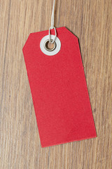 Red tag on wooden background