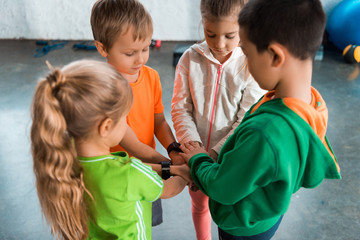 high angle view of multicultural children standing together in circle with united hands