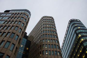 Fragment of the facade of a modern glass skyscraper with reflections and a lantern on the background of a cloudy sky with copy space