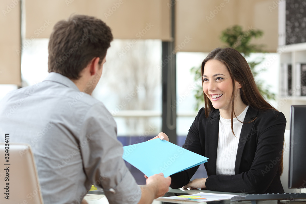 Employee giving folder to his manager during interview - obrazy, fototapety, plakaty 