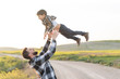 © FotoAndalucia - Father throwing his son in the air playing outdoors happy