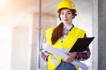 Portrait of a young girl builder with drawings in hand