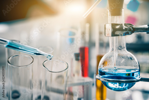 Cuadros en Lienzo dropping liquid to test tube containing chemical liquid in laboratory, lab chemistry or science research and development concept